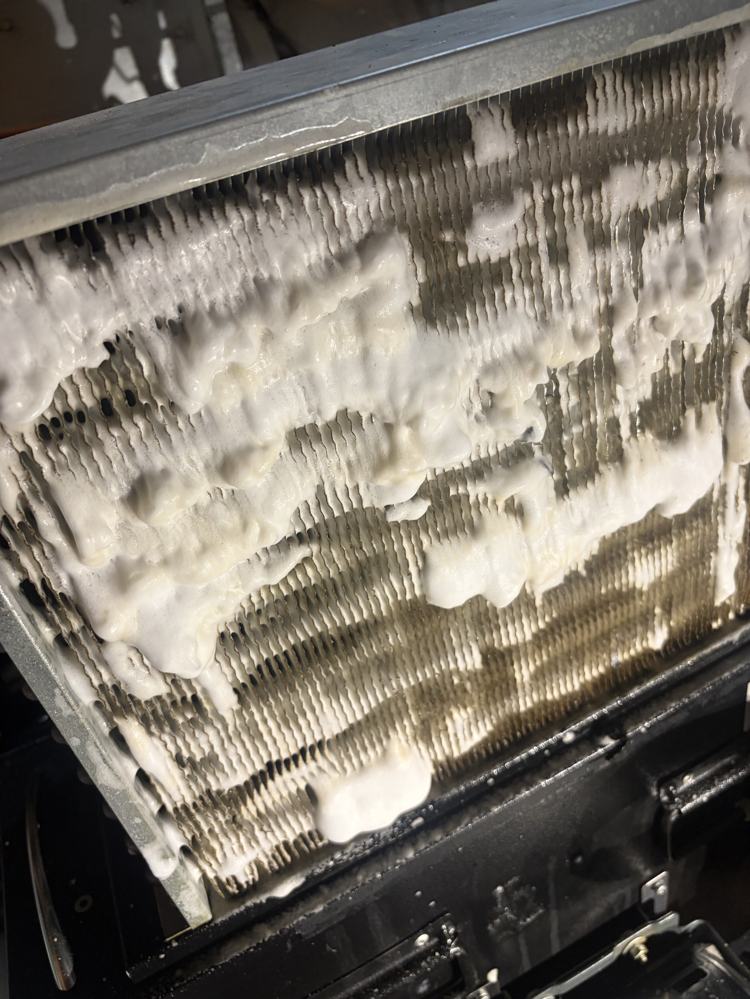 Coil covered in foaming cleaner mid-treatment